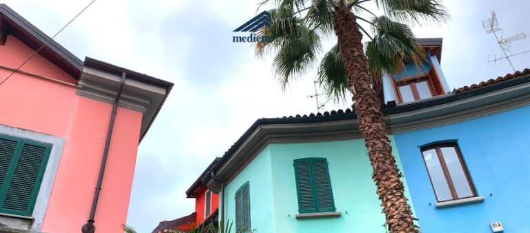 Case dai colori pastello e una palma nel Quartiere Lincoln a Milano